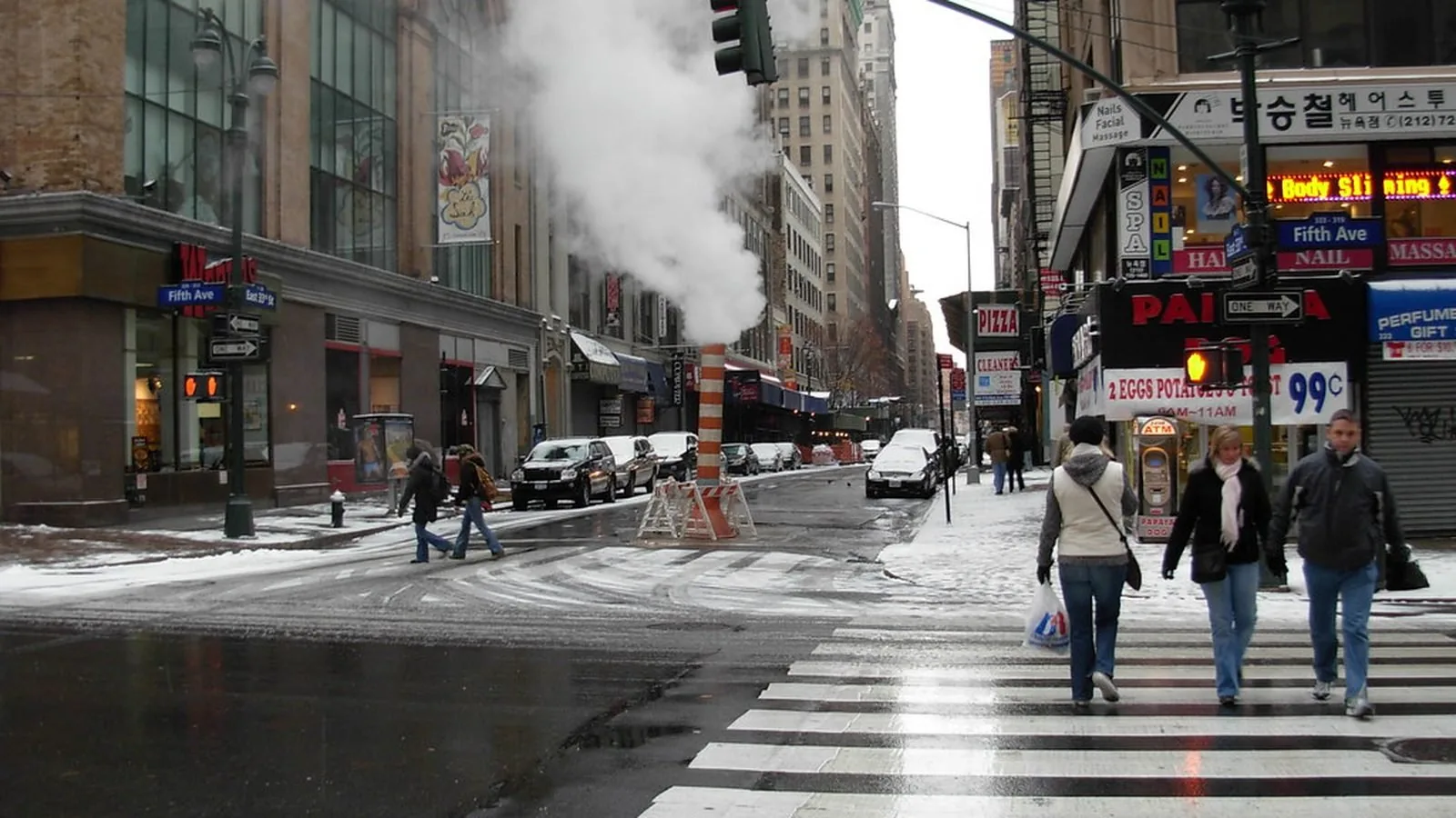 Steam rising from a vent on a city street