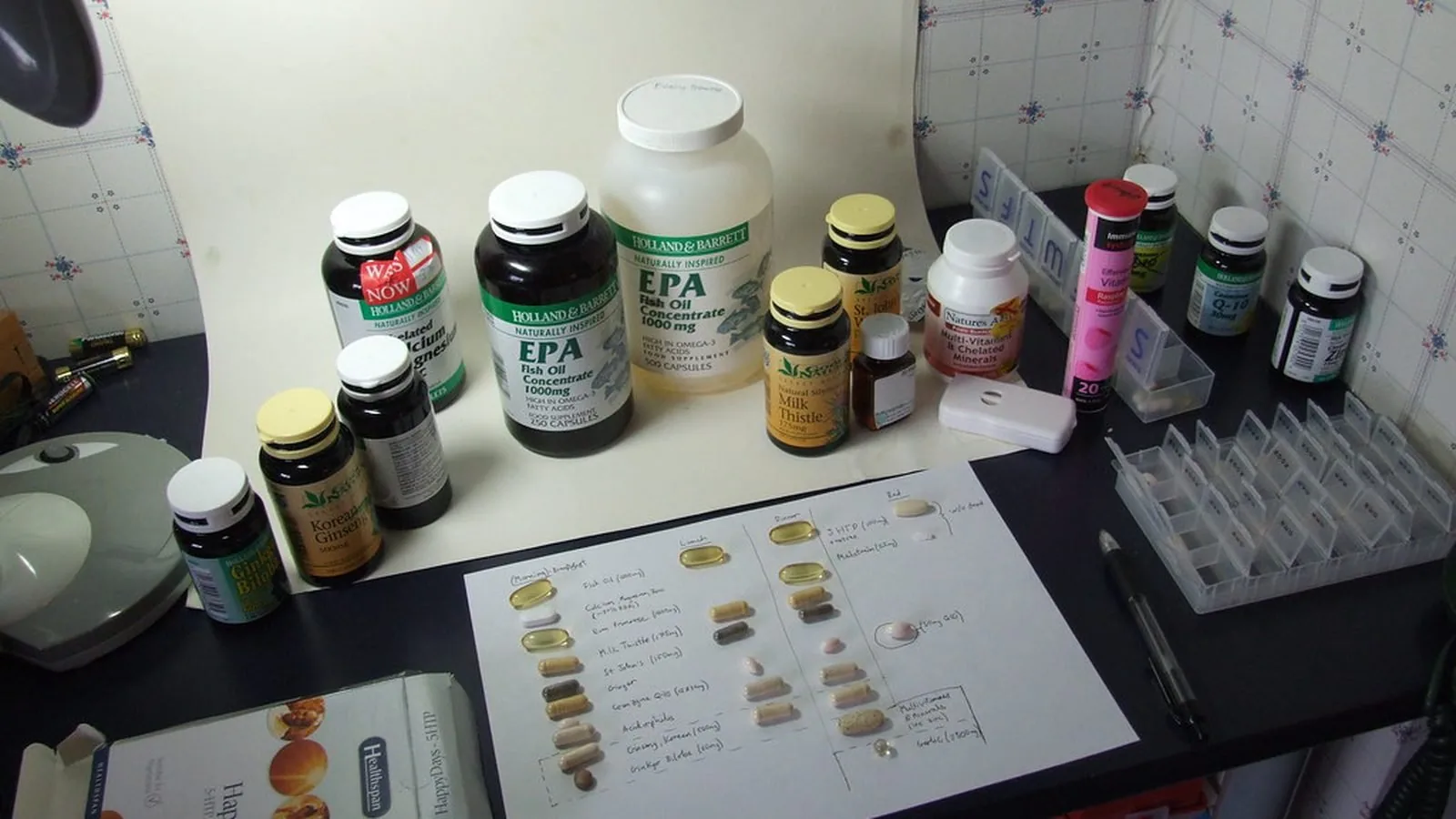 Several supplement bottles standing on a counter beside paperwork