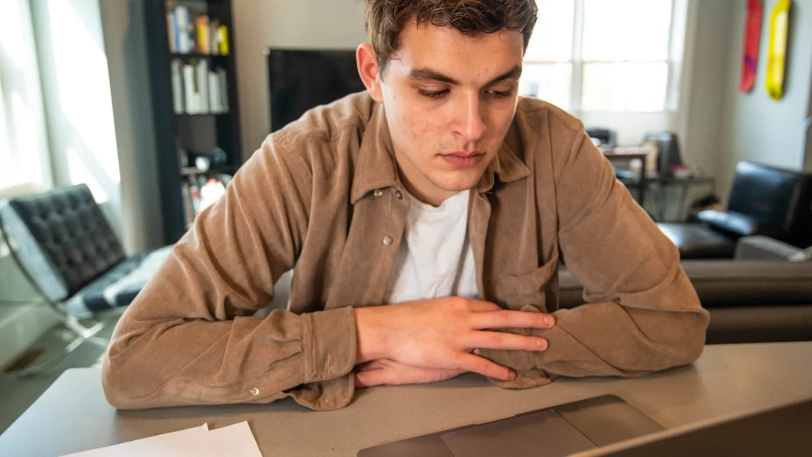 A man leaning forward over a laptop with his head held in front of his shoulders