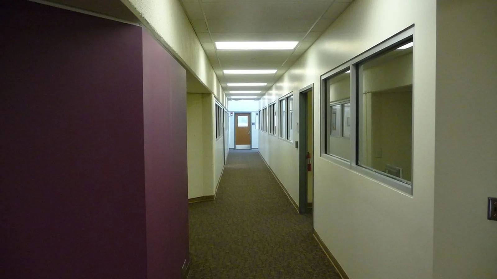 A long empty corridor with closed doors and no people